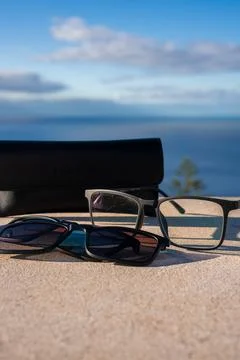 Two black glasses and case on stone near Atlantic coast in Madeira Stock Photos