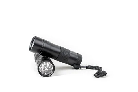 Two black LED flashlights resting on each other on a white background Stock Photos