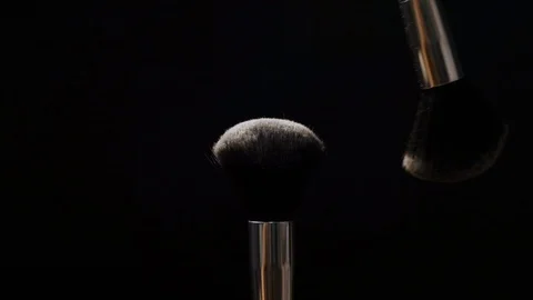Two black makeup brushes with powder or blush on a dark background. Beauty conce Stock Footage 118222754