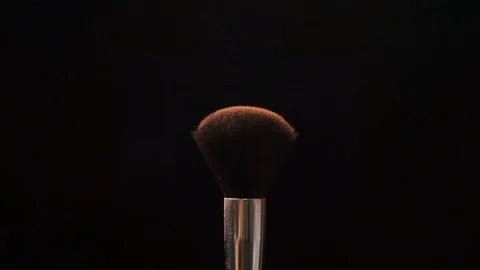 Two black makeup brushes with powder or blush on a dark background. Beauty conce Stock Footage 118224048