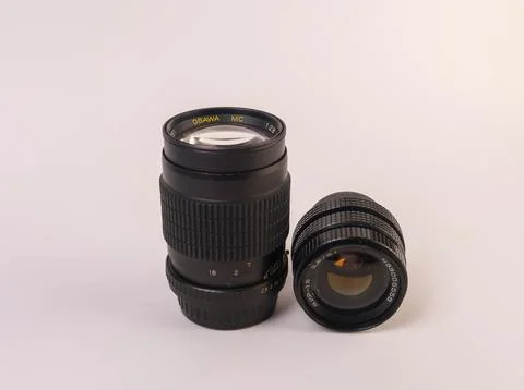Two black manual-focus camera lenses positioned side by side Stock Photos