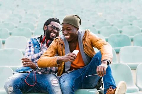 Two black race friends having fun with mobile. Stock Photos