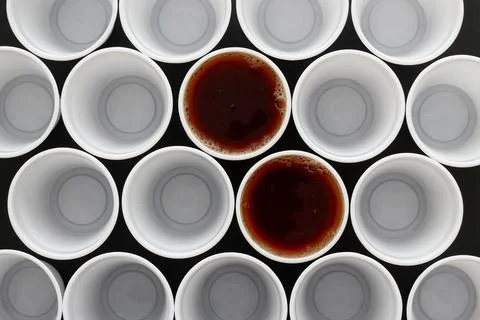Two black tea in plastic disposable cups together with many other cups Stock Photos