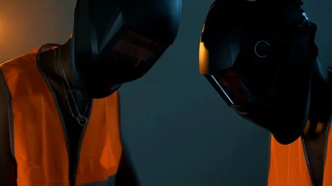 Two black workers put on welding masks before welding metal Stock Footage 128748147