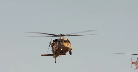 Two blackhawk helicopters fly in formation at low altitude Stock Footage 85503534