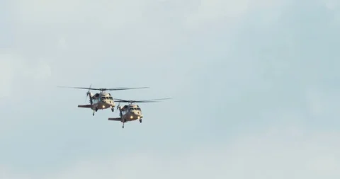 Two blackhawk helicopters fly at low altitude Stock Footage 85503260