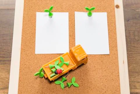 Two blank papers with green leaf pin and orange truck with pins Фото