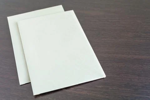 Two blank sheets of paper on a dark texture table Stock Photos