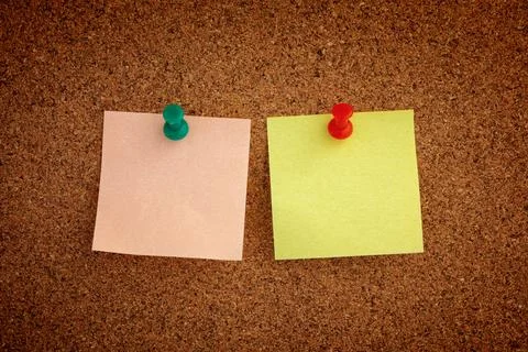 Two blank sticky notes pinned to a cork board Stock Photos
