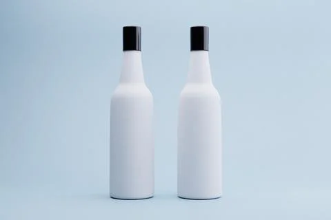 Two blank white bottles studio shot, light blue background, mockup Stock Illustration