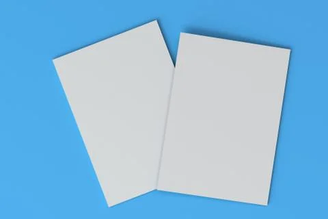 Two blank white closed brochure mock-up on blue background Stock Illustration