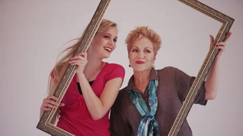 Two Blonde Models Play with Picture Frame in Photo Shoot Stock Footage 35296354
