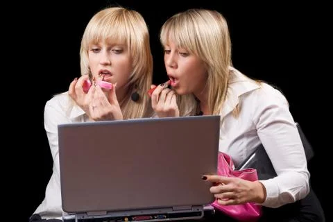 Two blondes do makeup in front of the laptop screen Stock Photos