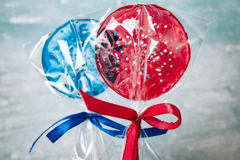 Two blue and two red lollipops isolated on blue background. Stock-Fotos