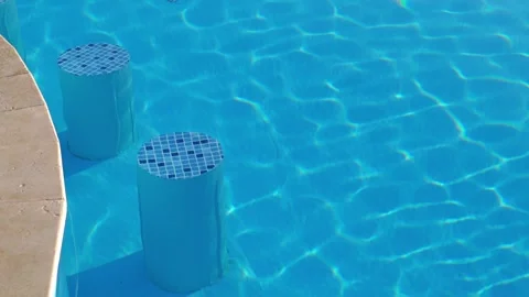 Two blue bar stools standing in a clear blue swimming pool Stock-Footage 312122833