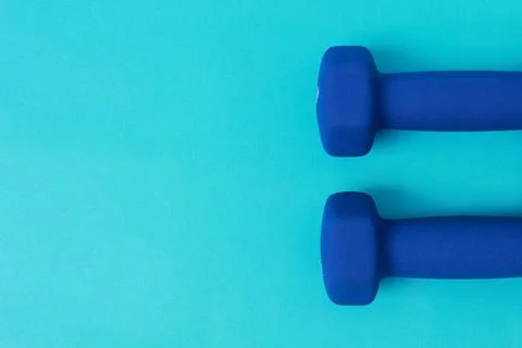 Two blue barbells on a blue background Stock Photos