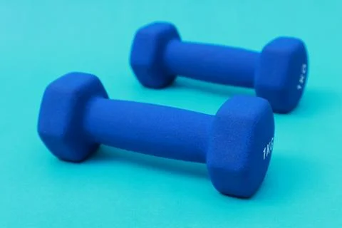 Two blue barbells on a blue background Stock Photos