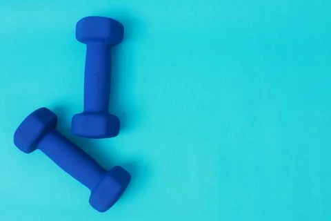 Two blue barbells on a blue background Stock Photos