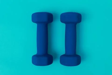 Two blue barbells on a blue background Stock Photos