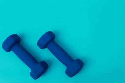 Two blue barbells on a blue background Stock Photos