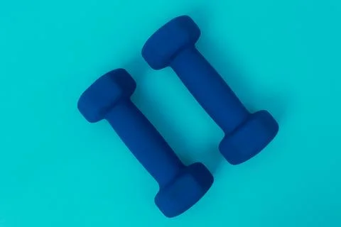 Two blue barbells on a blue background Stock Photos