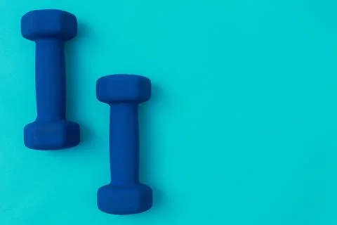 Two blue barbells on a blue background Stock Photos
