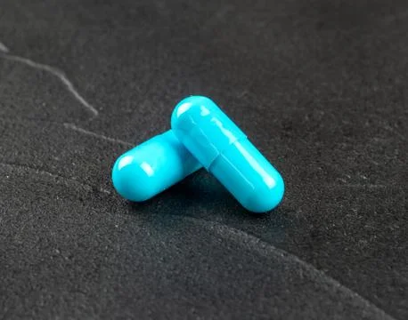 Two blue capsules Stock Photos