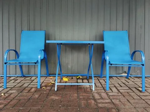 Two blue chairs around a table in a street cafe outside Stock Photos