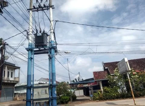 Two blue high-voltage power line poles stand side by side. Stock Photos