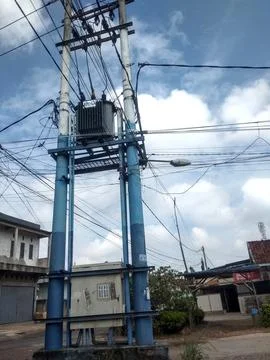 Two blue high-voltage power line poles stand side by side. Stock Photos