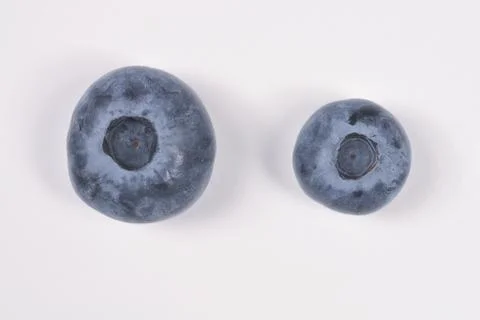 Two Blueberries of Different Sizes on White Background Foto stock