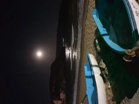 Two boat on the beach in the night with the moon in the sky Stock Photos