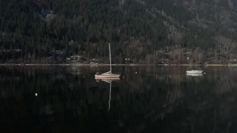 Two boats are floating reflecting in the water Stock Footage 222025632