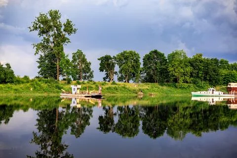 Two boats on a calm river surface before a thunderstorm. Trees in the backg.. Stock Photos