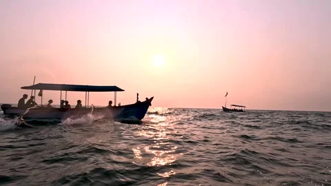 Two boats crossing on ocean waves during sunset with golden light in Goa India Stock Footage 331229841