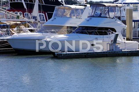 Two boats dock in a marina Stock Photos
