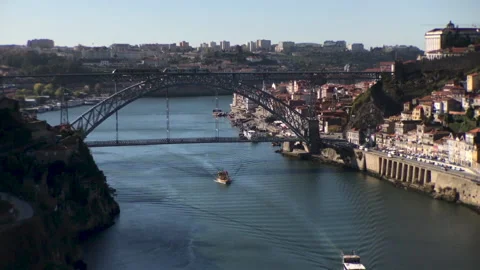 Two boats on Douro river sailing under the Dom Luís I Bridge in Porto Stock Footage 143398062