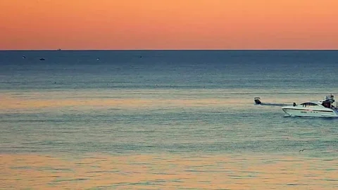 Two boats slowly making their way home during sunset Stock Footage 208596409
