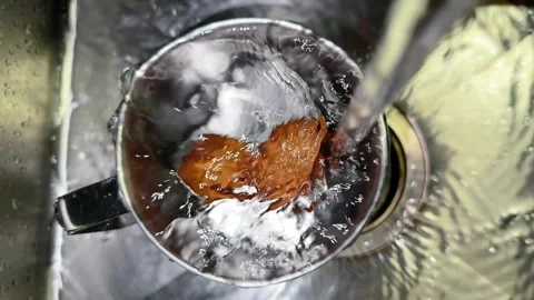 Two Boiled Eggs Cooling in Stainless Steel Mug Under Running Cold Water in Stock Footage 341457143