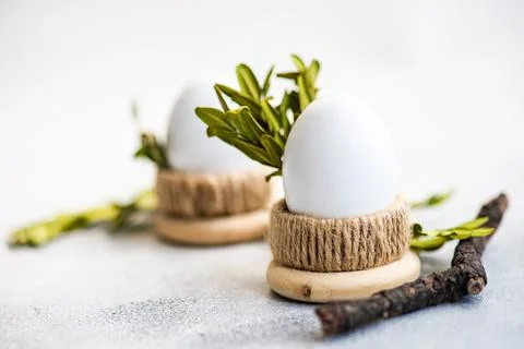 Two boiled eggs in egg cups with boxwood leaves Stock Photos