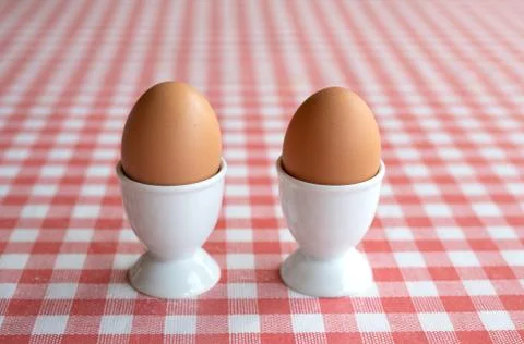 Two boiled eggs on a red and white background Stock Photos