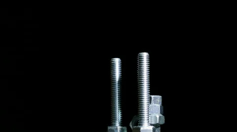 Two bolts with  nuts rotates against  dark background. 4K  close up centre side 库存影片 61458050