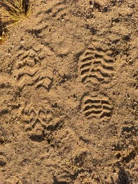Two boots footsteps on sand Stock Photos