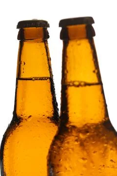 Two bottles of ale with drops. Close up. White background Stock Photos