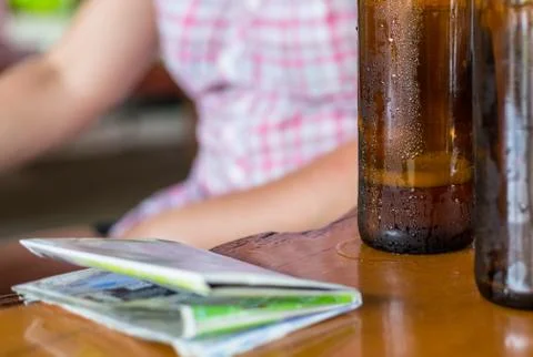 Two bottles of beer in a dark brown bottle with a tourist map on a wooden tab Stock Photos
