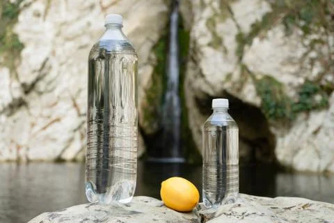 Two bottles of bottled drinking or mineral water on the background of a mount Stock Photos
