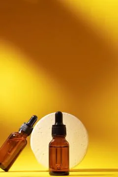 Two bottles different size with serum and podium. Stock Photos