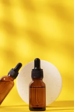 Two bottles different size with serum and podium. Skin care cosmetic. Stock Photos