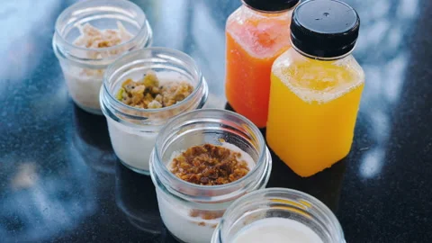 Two bottles of fresh squeezed juices and selection of different yogurt flavors Stock Footage 234209619