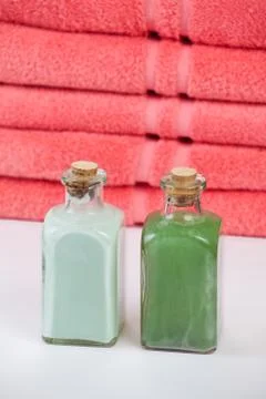Two bottles in front of towels Stock Photos